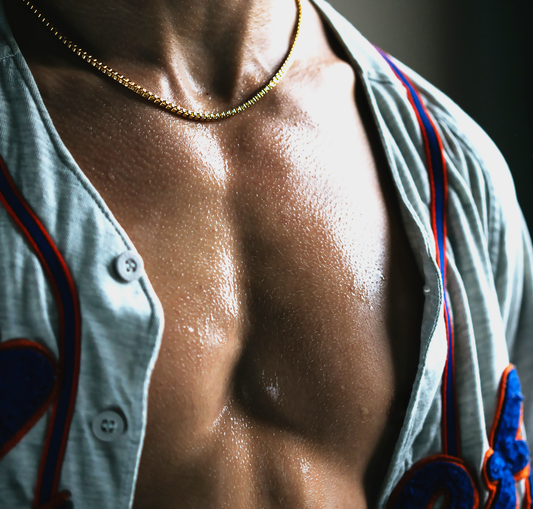 Close-up of a latino male's wet chest while wearing an unbuttoned sport jersey and a gold chain